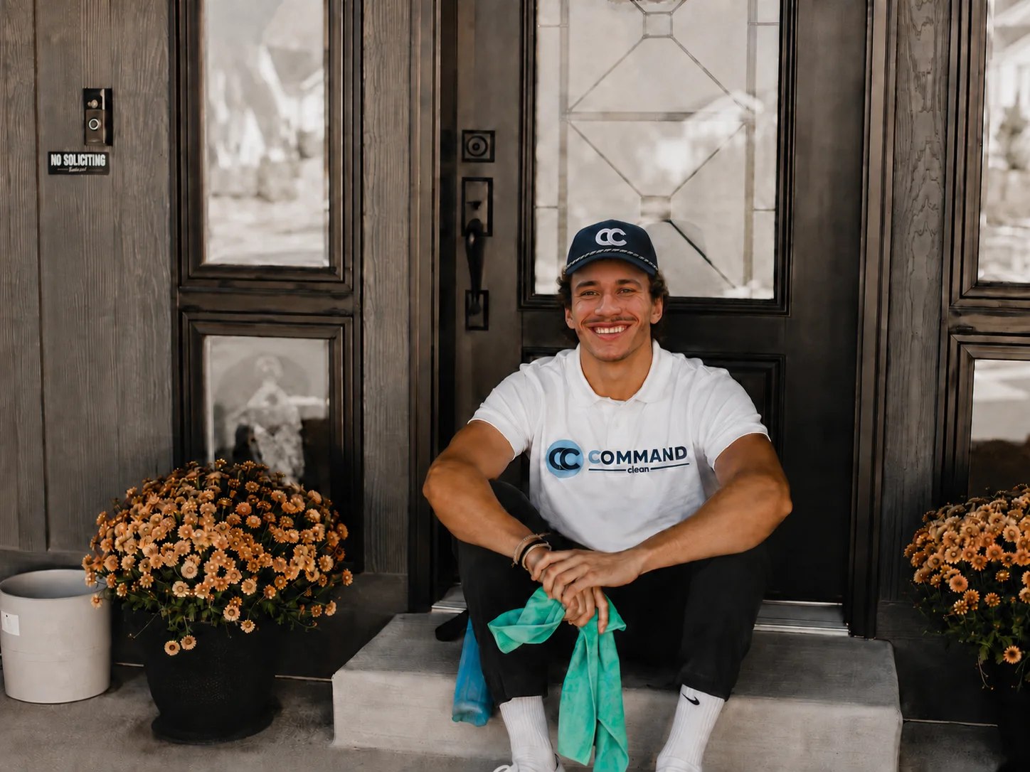 Command Clean founder in branded polo on a front porch step