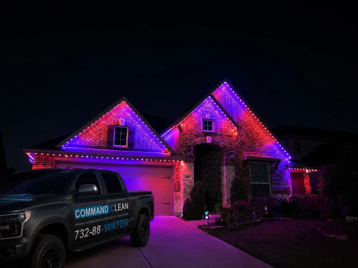 Home with color-changing permanent exterior lighting at night
